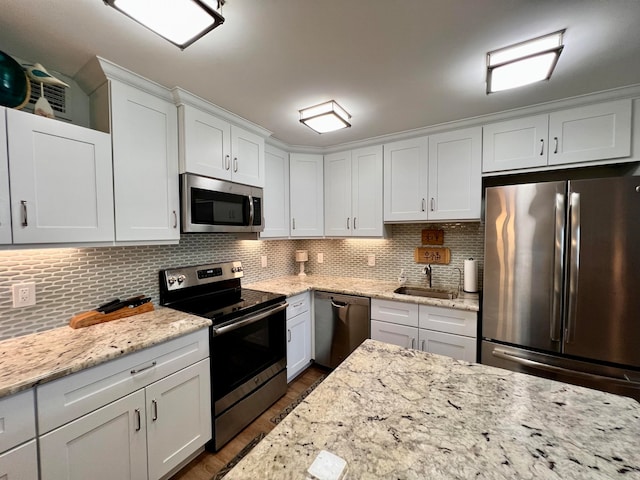 kitchen featuring stainless steel appliances, tasteful backsplash, sink, and white cabinetry