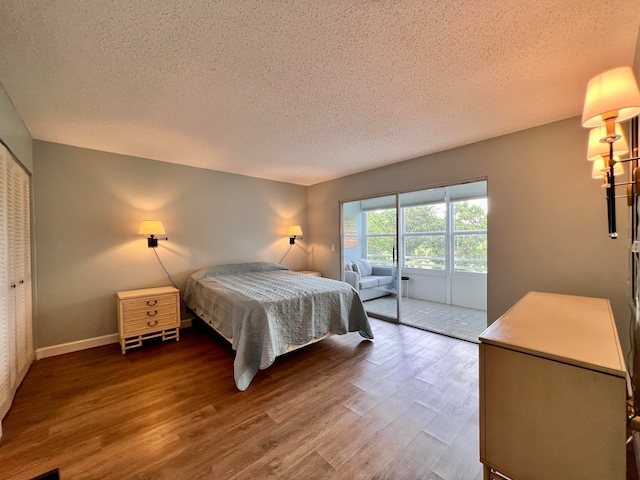 bedroom with a closet, hardwood / wood-style flooring, and a textured ceiling