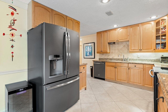 kitchen with tasteful backsplash, light stone countertops, light tile patterned flooring, sink, and stainless steel appliances