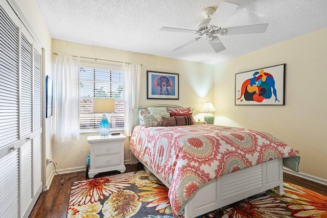 bedroom featuring a closet, dark hardwood / wood-style floors, a textured ceiling, and ceiling fan