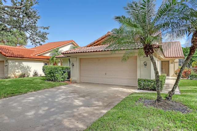 mediterranean / spanish house featuring a front lawn and a garage