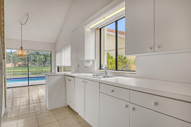 kitchen with white cabinetry, decorative light fixtures, sink, lofted ceiling, and a textured ceiling