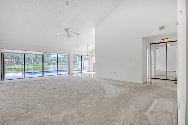 unfurnished living room featuring a textured ceiling, high vaulted ceiling, ceiling fan, and light colored carpet