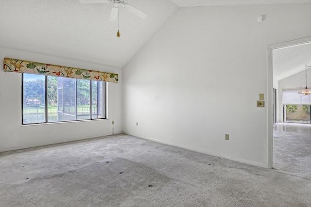 spare room with ceiling fan, vaulted ceiling, carpet, and a textured ceiling