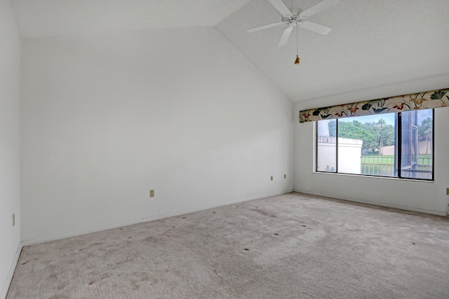 empty room with ceiling fan, light colored carpet, and vaulted ceiling