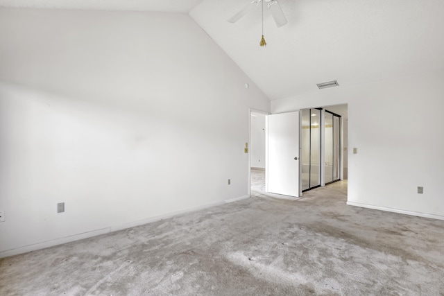 carpeted spare room featuring high vaulted ceiling and ceiling fan