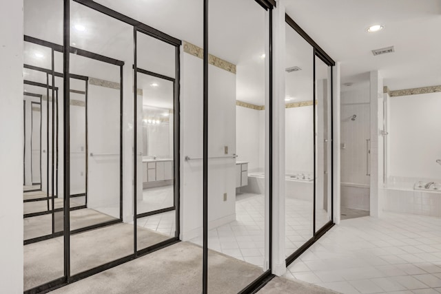 bathroom with tile patterned floors and a tub to relax in