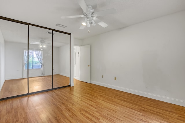 unfurnished bedroom with ceiling fan, a closet, and light hardwood / wood-style flooring