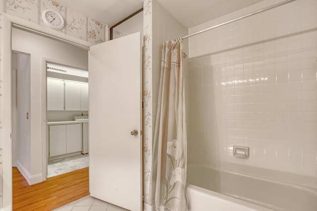 bathroom with shower / bathtub combination with curtain and wood-type flooring