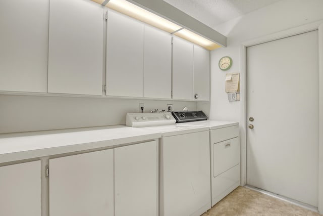 laundry room with washer and clothes dryer, cabinets, and a textured ceiling