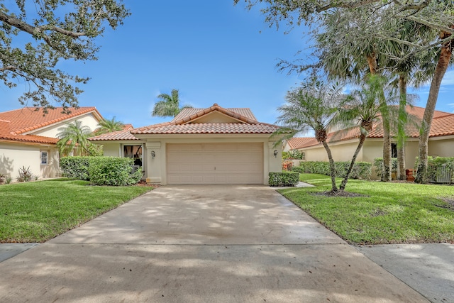 mediterranean / spanish-style home featuring a front yard and a garage