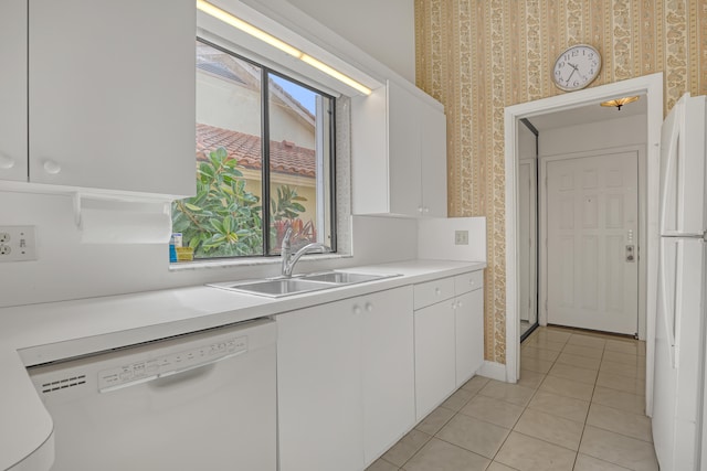 kitchen featuring light tile patterned flooring, sink, white appliances, and white cabinetry