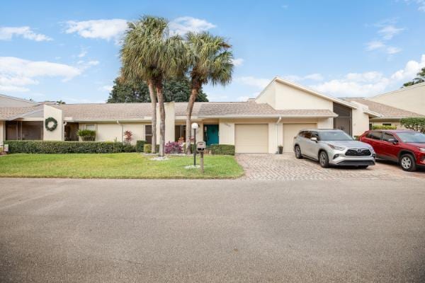 ranch-style house featuring a garage and a front yard