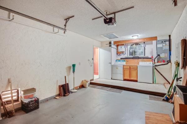 garage featuring heating unit, a garage door opener, and washing machine and clothes dryer