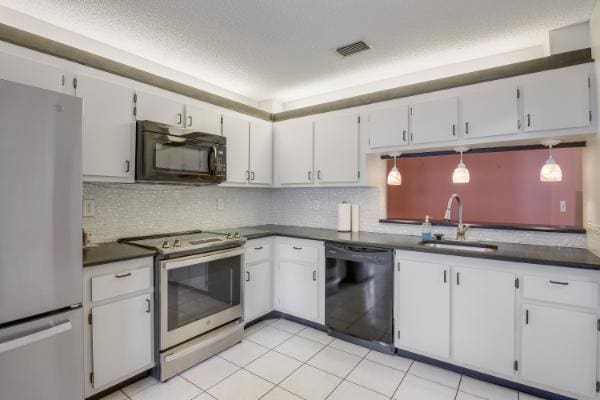 kitchen featuring sink, black appliances, pendant lighting, white cabinets, and light tile patterned flooring