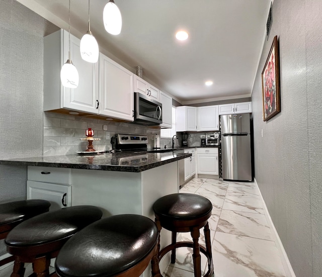 kitchen with stainless steel appliances, kitchen peninsula, and white cabinetry