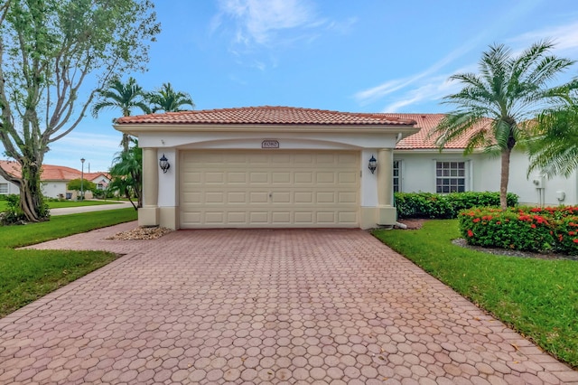 mediterranean / spanish home featuring a front yard and a garage