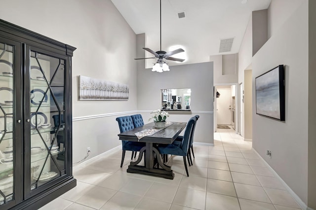 tiled dining space with high vaulted ceiling and ceiling fan