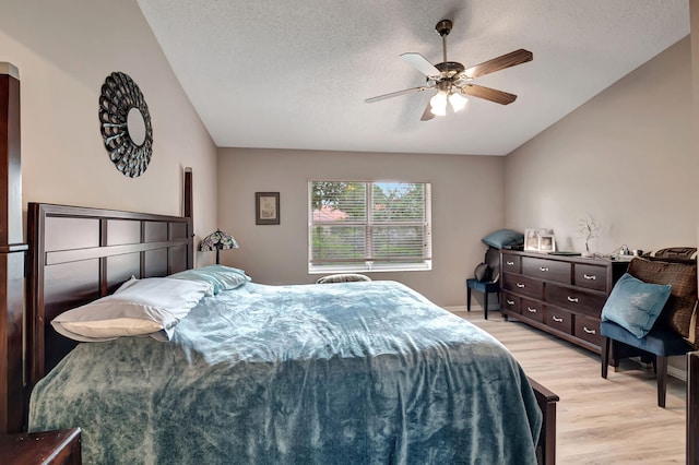 bedroom featuring ceiling fan, light hardwood / wood-style floors, and a textured ceiling