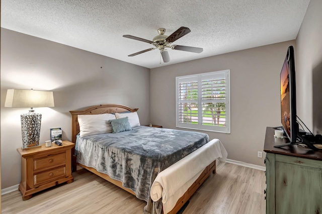 bedroom featuring a textured ceiling, light wood-type flooring, and ceiling fan