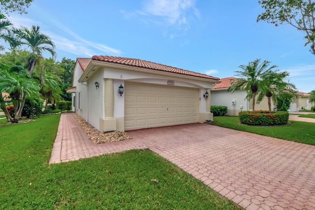 mediterranean / spanish home featuring a garage and a front lawn