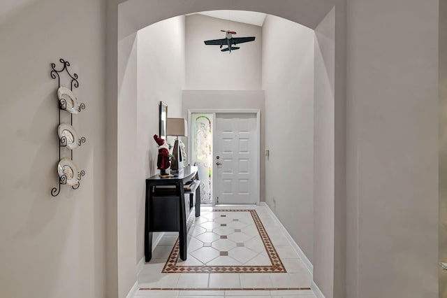 foyer entrance with light tile patterned floors and a high ceiling