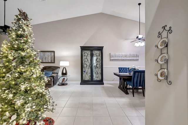 foyer entrance with lofted ceiling, light tile patterned floors, and ceiling fan