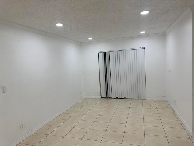 tiled spare room with crown molding and a textured ceiling