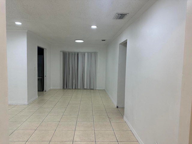 tiled empty room with a textured ceiling