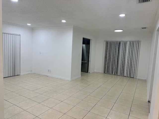 tiled spare room with a textured ceiling