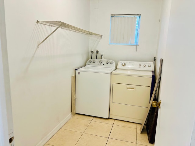 clothes washing area featuring washer and dryer and light tile patterned floors