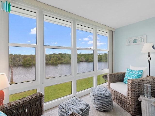 sunroom featuring a water view