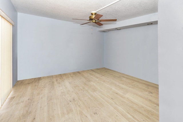 spare room with ceiling fan, light hardwood / wood-style flooring, and a textured ceiling