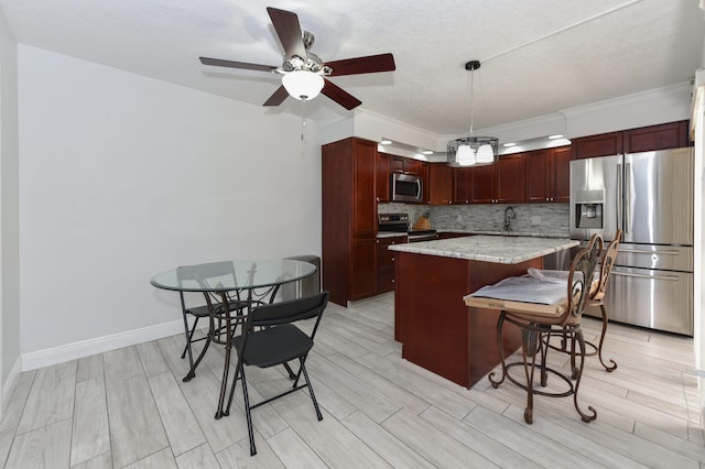 kitchen featuring stainless steel appliances, pendant lighting, ornamental molding, and a center island