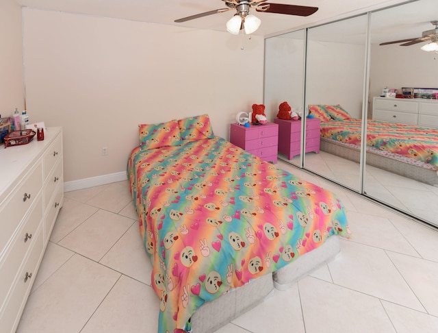 bedroom featuring ceiling fan, a closet, and light tile patterned floors