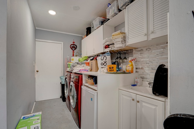 laundry area with ornamental molding, washer and dryer, and sink