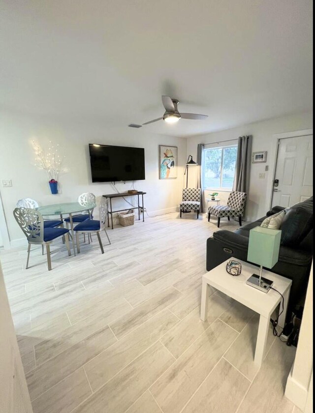 living room featuring ceiling fan and wood-type flooring