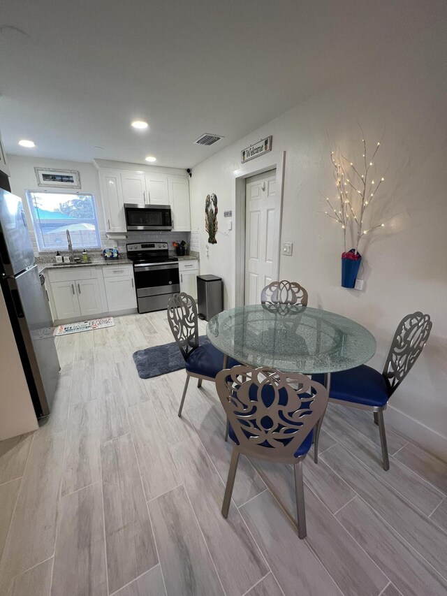 dining area featuring sink and light hardwood / wood-style flooring