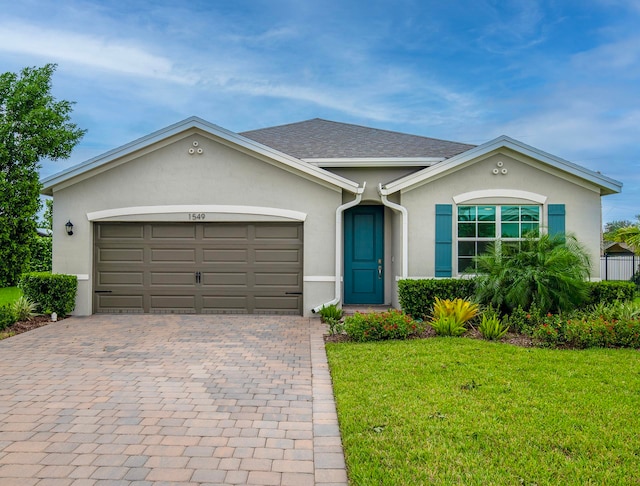 single story home featuring a front lawn and a garage