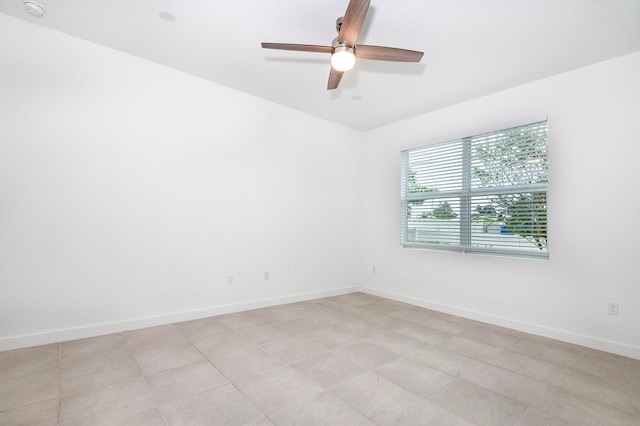 tiled spare room with ceiling fan