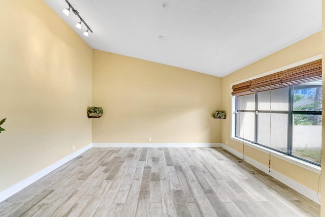 unfurnished room featuring light hardwood / wood-style flooring and vaulted ceiling