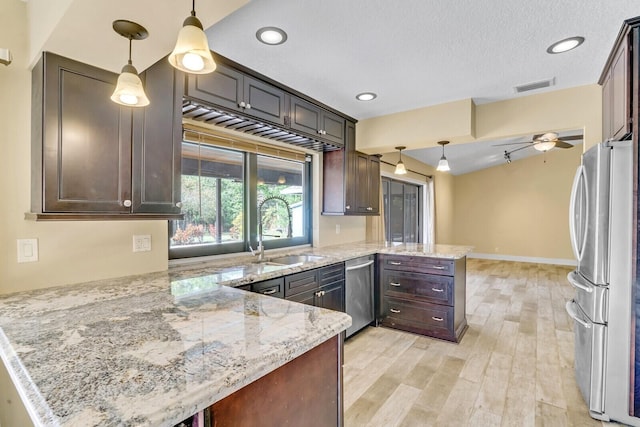 kitchen featuring kitchen peninsula, pendant lighting, stainless steel appliances, and dark brown cabinets