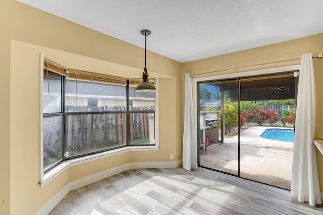 unfurnished dining area with plenty of natural light and light hardwood / wood-style flooring