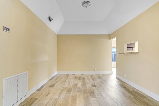 empty room featuring light hardwood / wood-style flooring and high vaulted ceiling