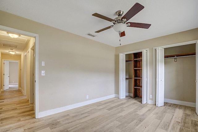 unfurnished bedroom with multiple closets, ceiling fan, and light hardwood / wood-style flooring