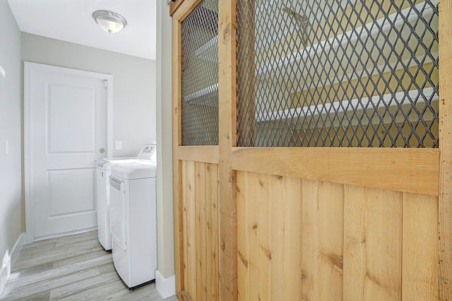 washroom featuring light wood-type flooring and washing machine and clothes dryer