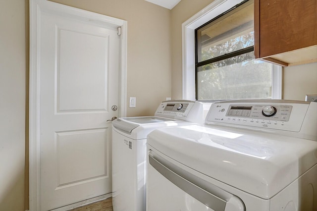 washroom featuring cabinets and independent washer and dryer