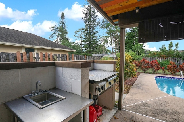 view of patio / terrace with a fenced in pool and sink