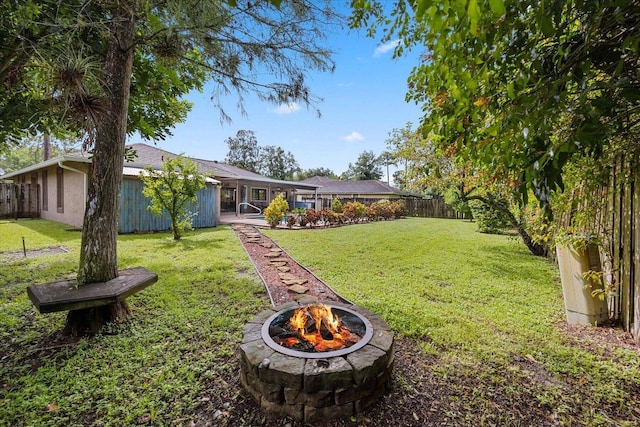 view of yard featuring a fire pit and a sunroom