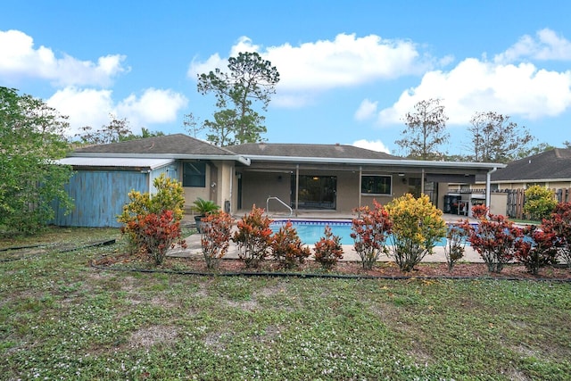 rear view of property with a fenced in pool